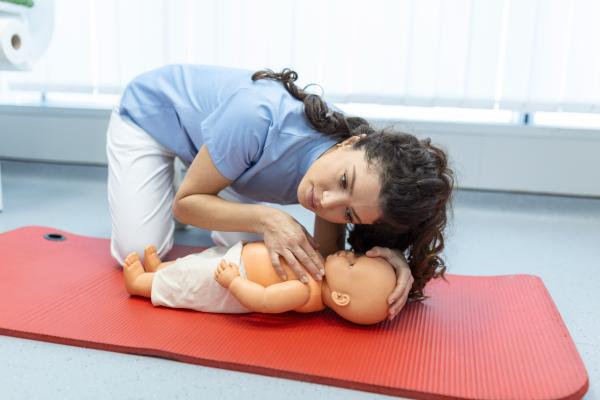 Trainer doing CPR on baby doll