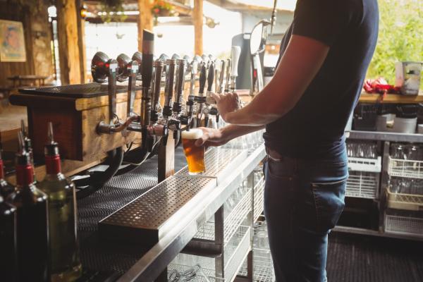 Barman pouring pint in bar
