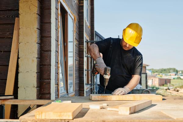 Builder drilling wood blocks