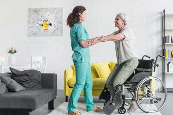 Nurse helping elderly wheelchair user