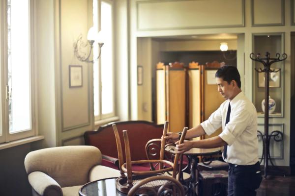 Waiter moving chairs in restaurant