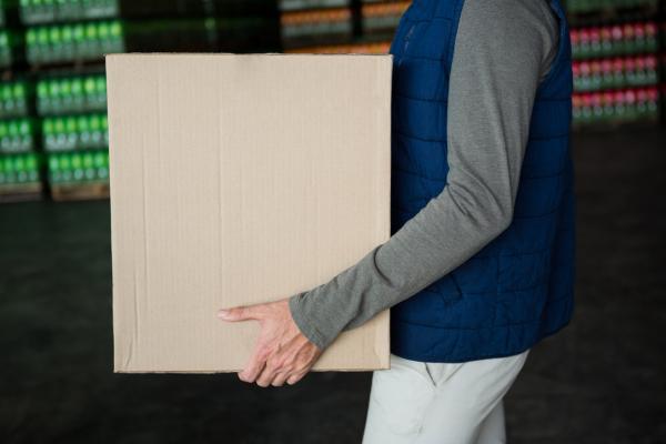 Worker carrying box in warehouse